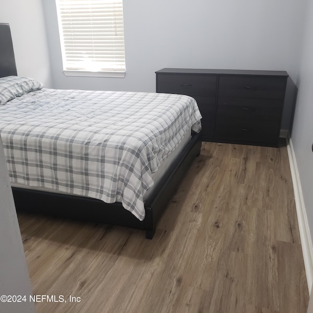 bedroom featuring wood finished floors and baseboards