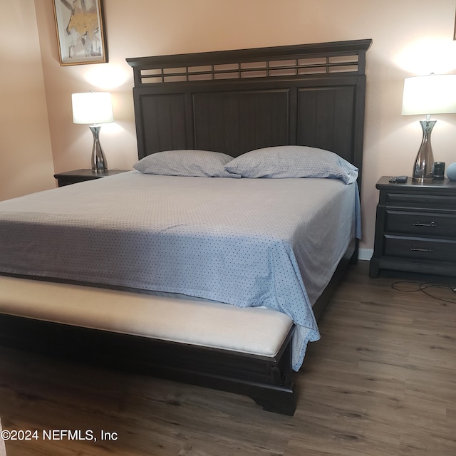 bedroom featuring wood finished floors and baseboards