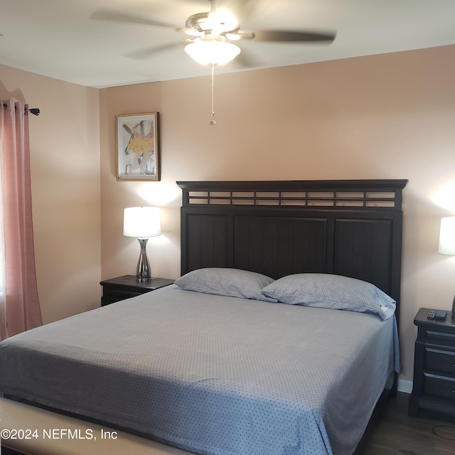 bedroom with a ceiling fan and dark wood-style flooring