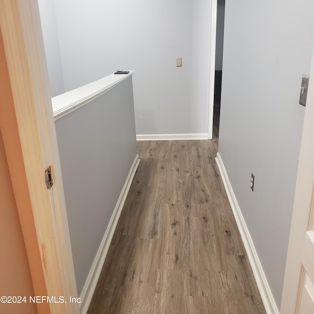 hallway featuring baseboards and wood finished floors