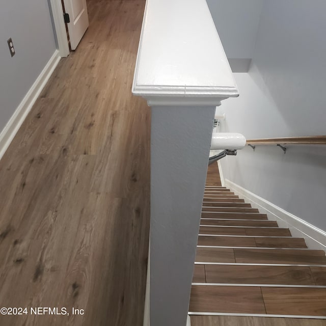 staircase with wood finished floors and baseboards