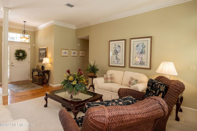 living room featuring hardwood / wood-style floors, ornamental molding, and ornate columns