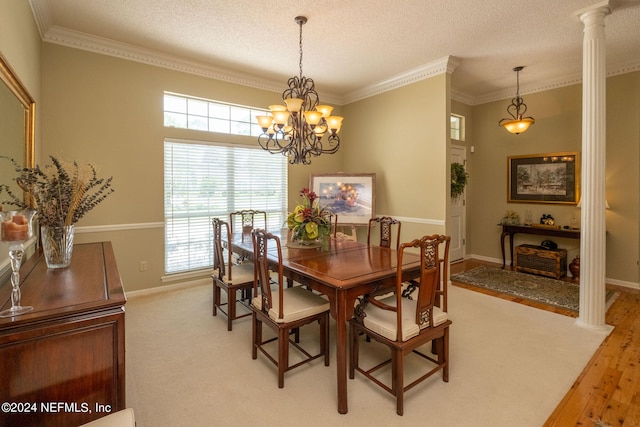 dining room featuring hardwood / wood-style flooring, ornamental molding, plenty of natural light, and ornate columns