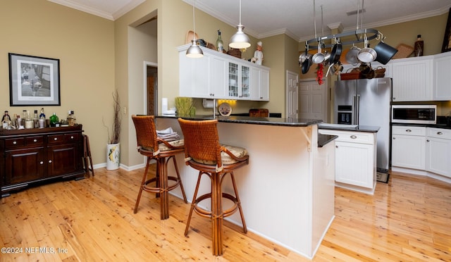 kitchen with crown molding, high end refrigerator, a kitchen bar, and a kitchen island