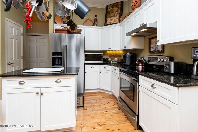 kitchen featuring light wood-type flooring, white cabinetry, stainless steel appliances, and crown molding