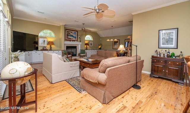 living room featuring a fireplace, ornamental molding, light hardwood / wood-style floors, and ceiling fan