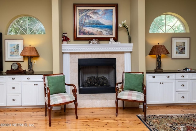 living area featuring light hardwood / wood-style flooring and a tile fireplace