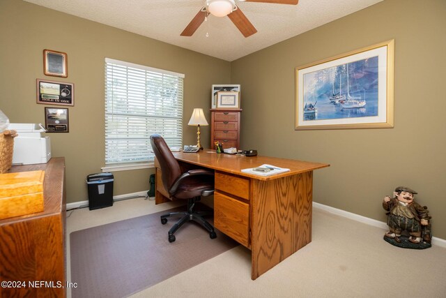 office space featuring light carpet, a textured ceiling, and ceiling fan