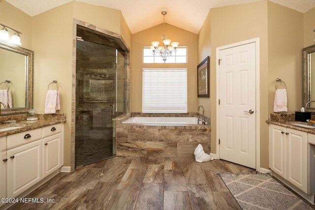 bathroom featuring vanity, vaulted ceiling, an inviting chandelier, and independent shower and bath