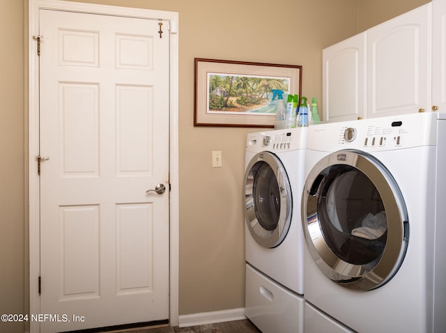 washroom with dark hardwood / wood-style floors, cabinets, and separate washer and dryer