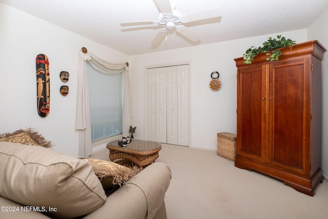 living room with light carpet, a textured ceiling, and ceiling fan