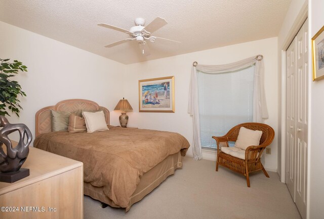 bedroom featuring a closet, a textured ceiling, and carpet