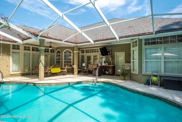 view of swimming pool with outdoor lounge area, ceiling fan, a lanai, and a patio area