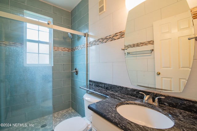 bathroom featuring toilet, a shower stall, visible vents, and vanity