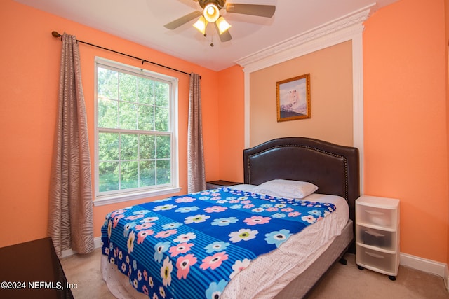 carpeted bedroom featuring multiple windows and ceiling fan