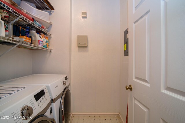 laundry room with washing machine and dryer and light tile patterned floors