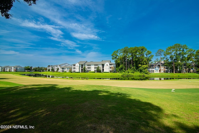 view of community featuring view of golf course, a residential view, and a lawn