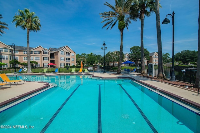 community pool featuring a patio and fence