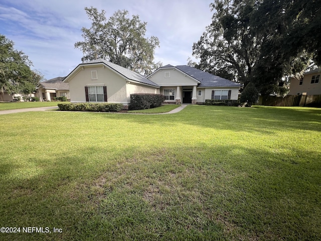 single story home featuring a front yard and stucco siding