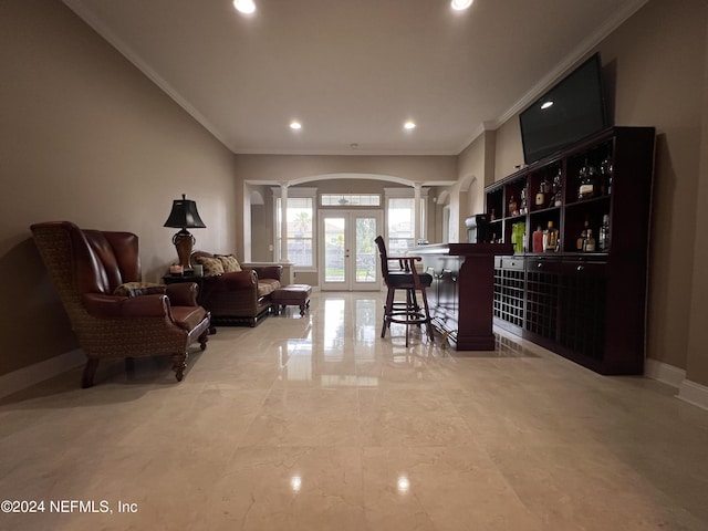 bar featuring french doors, decorative columns, ornamental molding, a bar, and baseboards