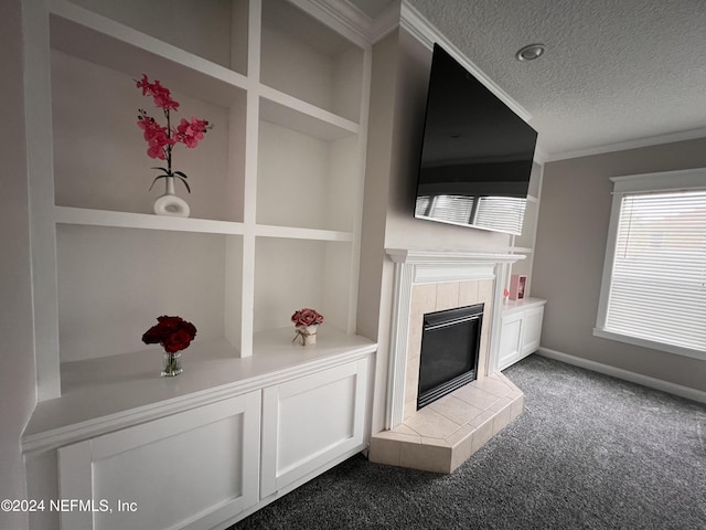 unfurnished living room with ornamental molding, carpet flooring, a textured ceiling, a tile fireplace, and baseboards