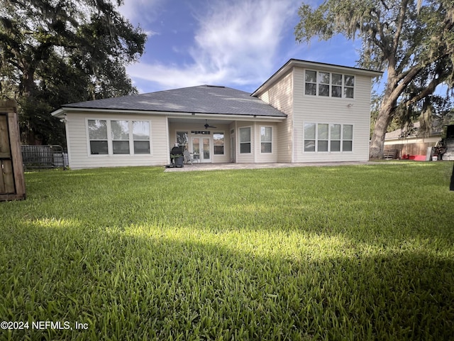 rear view of property with ceiling fan, fence, a lawn, and a patio