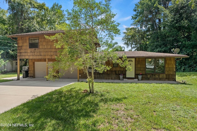 view of front of property featuring a garage and a front lawn