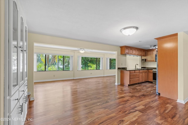 kitchen with sink, dark wood-type flooring, stainless steel range, and ceiling fan