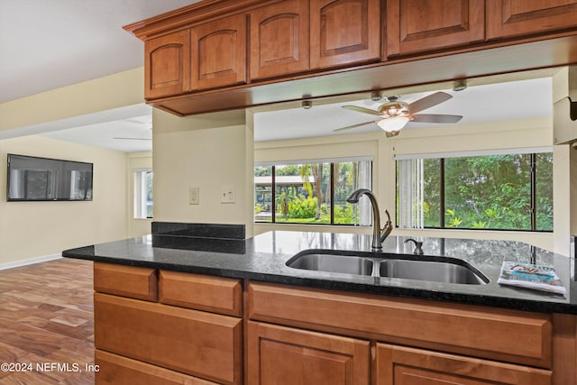 kitchen with sink, dark stone countertops, and ceiling fan