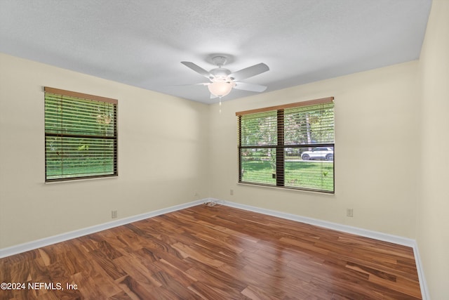 empty room with a textured ceiling, hardwood / wood-style floors, and ceiling fan