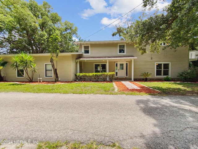 view of front of property with a porch and a front yard