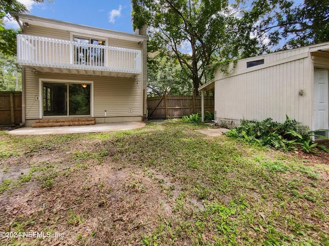 back of house featuring a balcony, a lawn, and a patio area