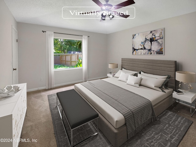 bedroom with ceiling fan, dark colored carpet, and a textured ceiling