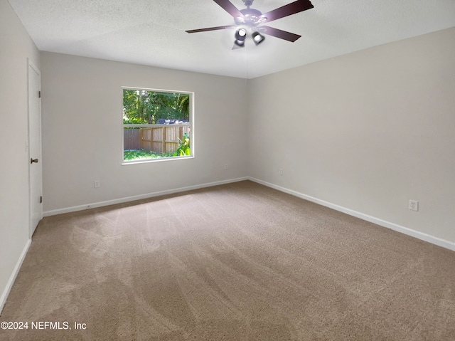 carpeted empty room featuring a textured ceiling and ceiling fan