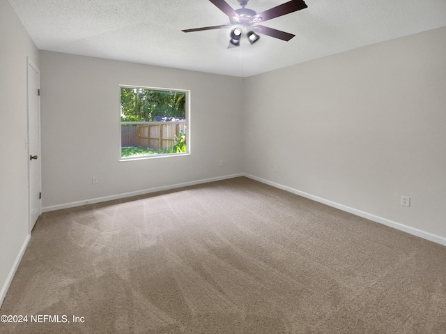 spare room featuring carpet, ceiling fan, and a textured ceiling