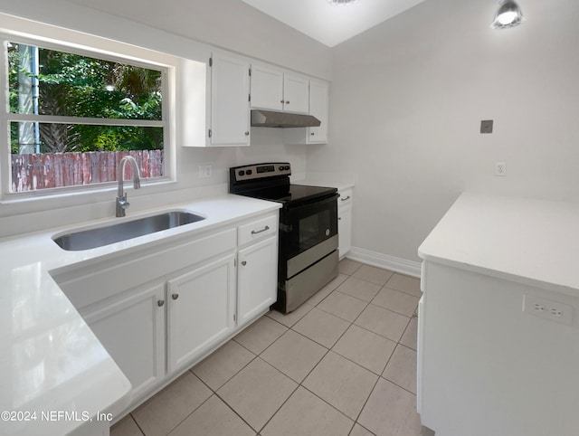 kitchen featuring sink, stainless steel electric range, white cabinets, and light tile patterned floors