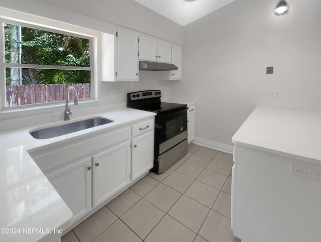 kitchen with electric stove, sink, white cabinetry, and light tile patterned floors
