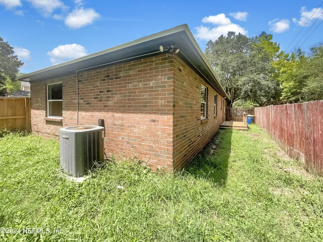view of side of home with a yard and central air condition unit