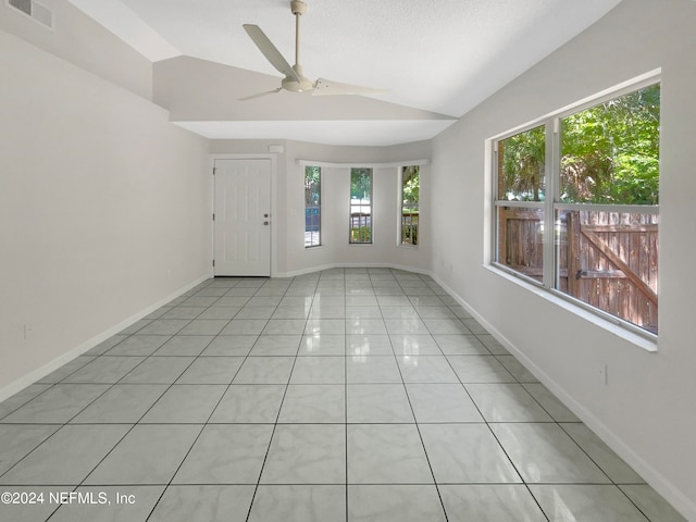 unfurnished room with vaulted ceiling, light tile patterned floors, and ceiling fan