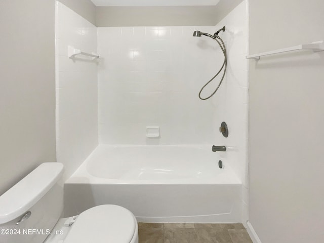 bathroom with tile patterned flooring, tiled shower / bath combo, and toilet