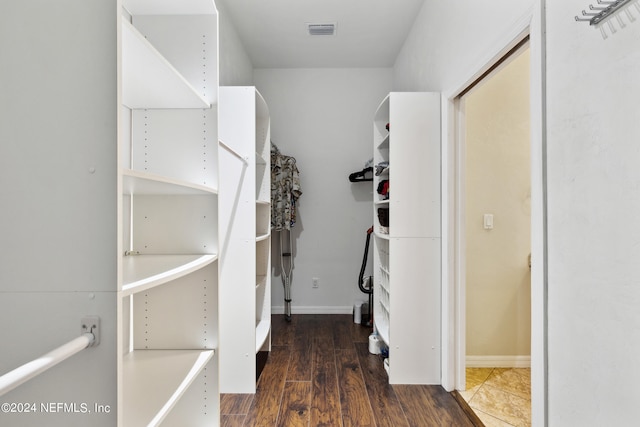 spacious closet with dark wood-type flooring