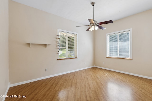 empty room with ceiling fan and light hardwood / wood-style flooring