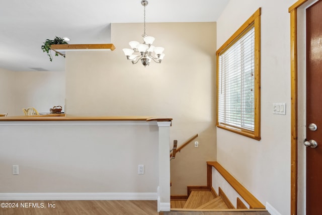 staircase with a chandelier and hardwood / wood-style flooring