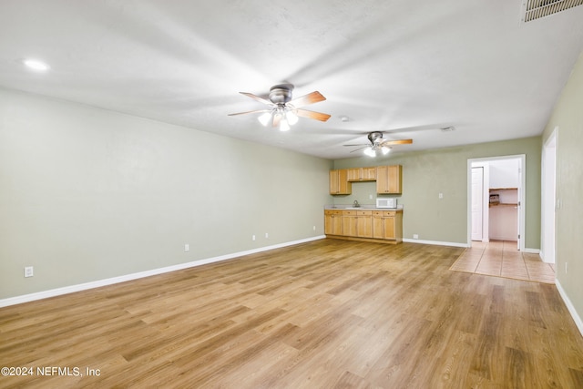 unfurnished living room featuring ceiling fan and light tile patterned flooring