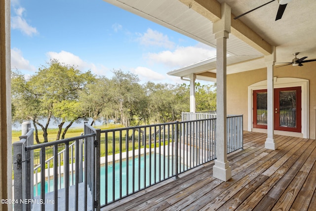 deck with ceiling fan and a fenced in pool