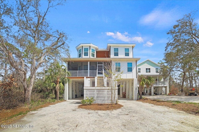 49 SW 279th Ave, Steinhatchee, FL 32359 - raised beach house featuring a sunroom, a carport, and dirt driveway