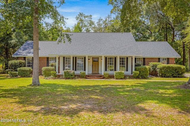 ranch-style house featuring a front yard and covered porch