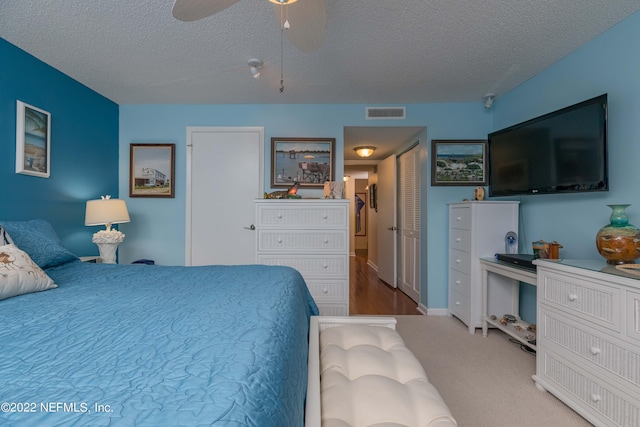 carpeted bedroom with a textured ceiling and ceiling fan