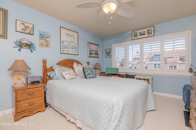 bedroom with light colored carpet, a textured ceiling, and ceiling fan