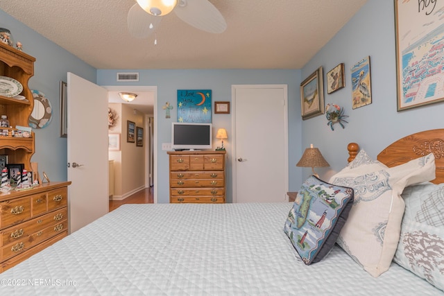 bedroom with a textured ceiling and ceiling fan